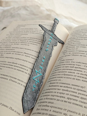 Sword bookmark with Norse runes and fantasy design on an open book.