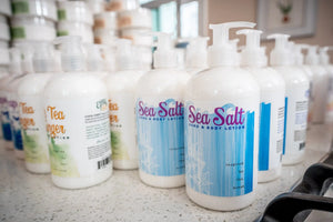 White pump bottles of Sea Salt Hand & Body Lotion with ocean-inspired labels.