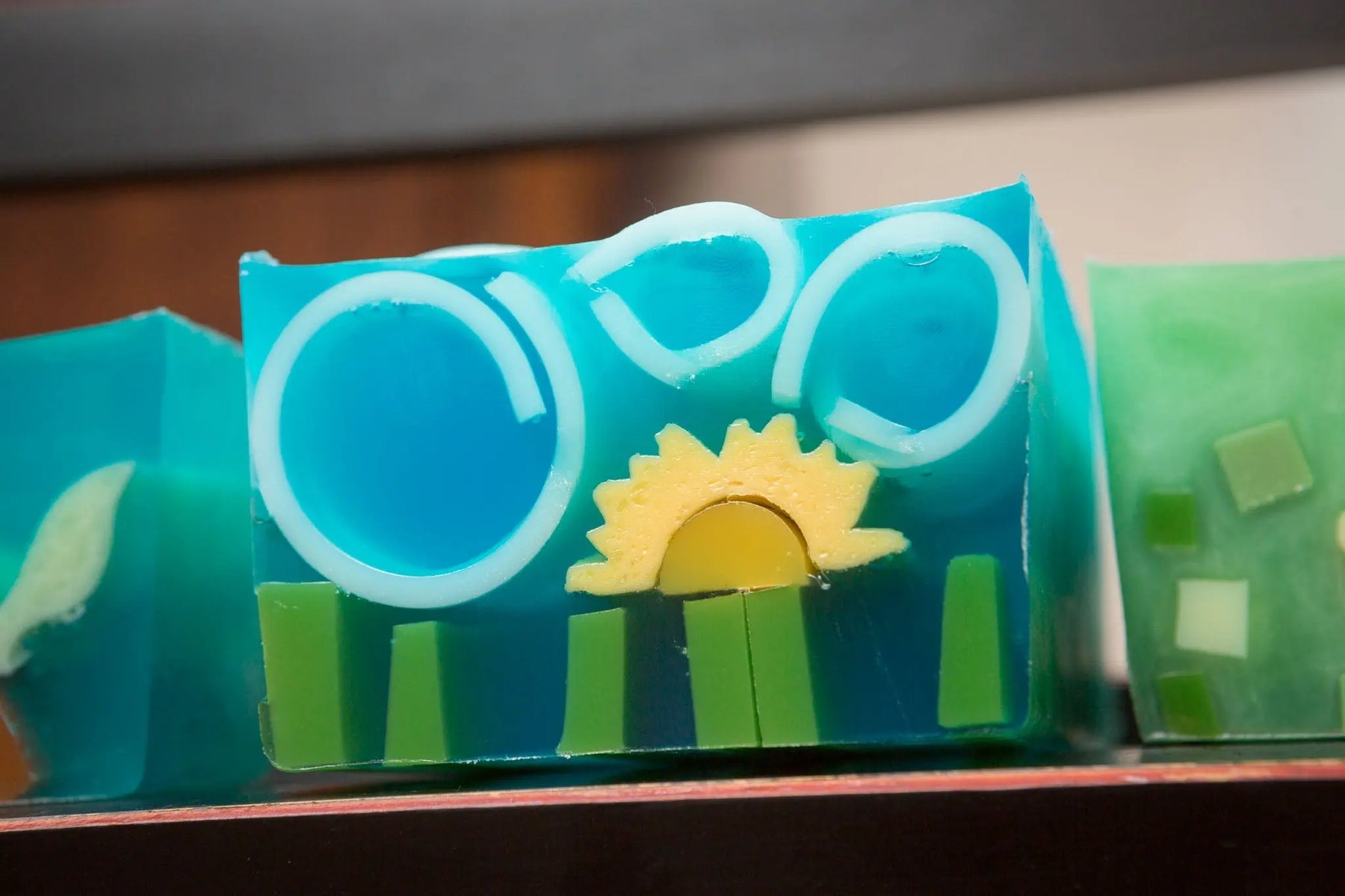 Blue and green layered soap with a white ring and sun design