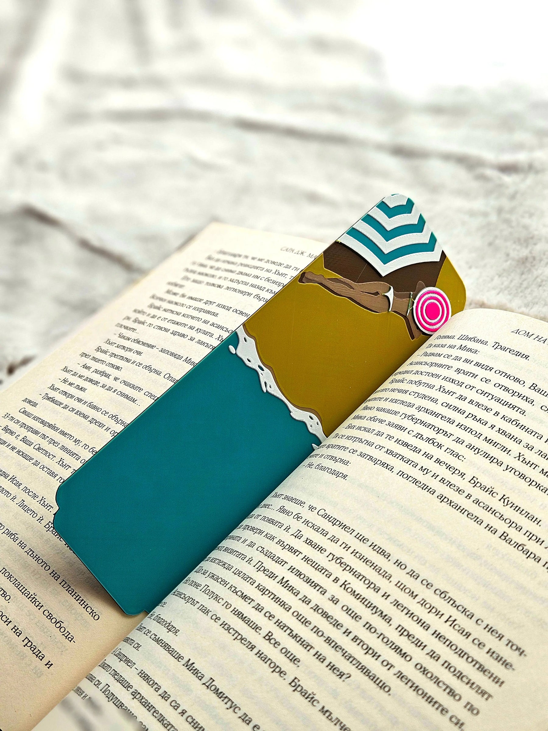 Teal and yellow beach umbrella bookmark in an open book.