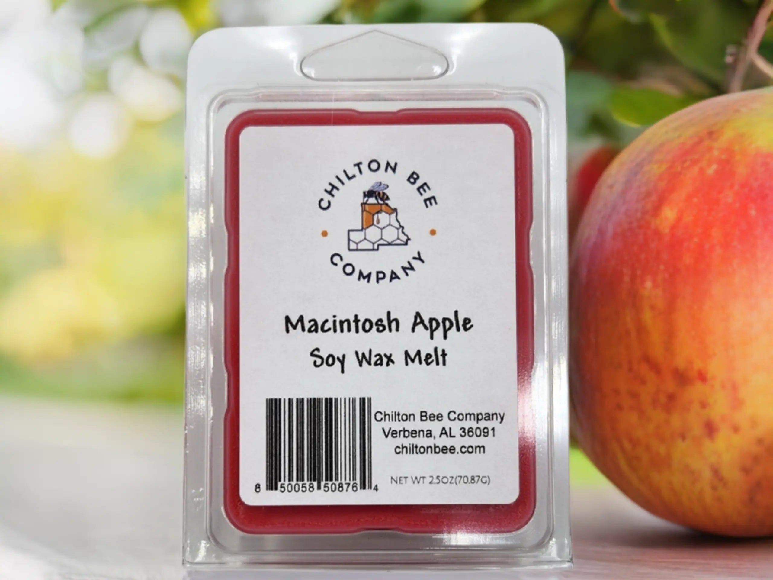 Chilton Bee Company Macintosh Apple soy wax melt in a clear plastic package next to a red and yellow apple.