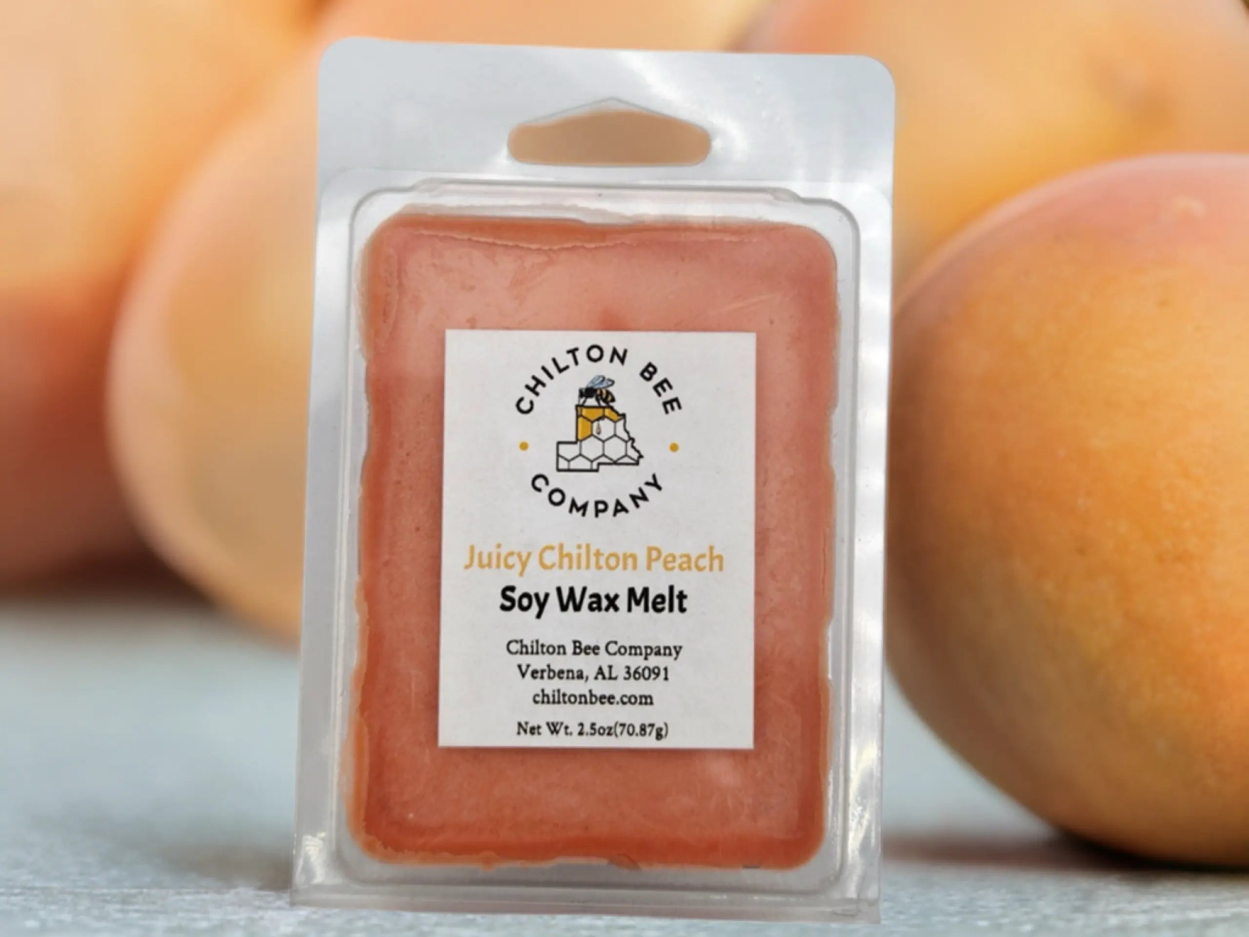 Chilton Bee Company Juicy Chilton Peach Soy Wax Melt in clear packaging, with blurred peaches in the background.
