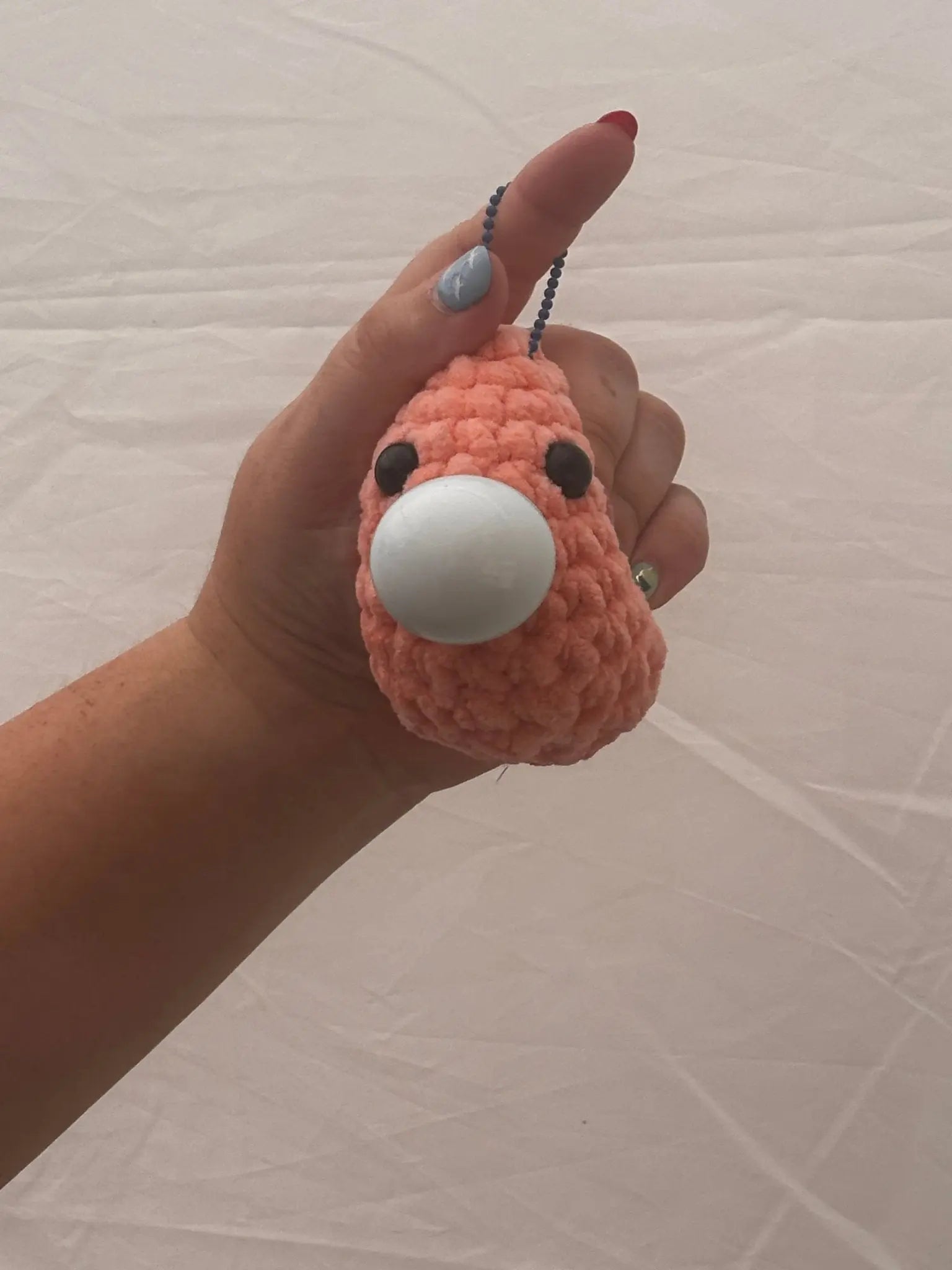 Hand holding a pink Stress Blob plush toy from Main Street Collective - cute, squeezable stress reliever.