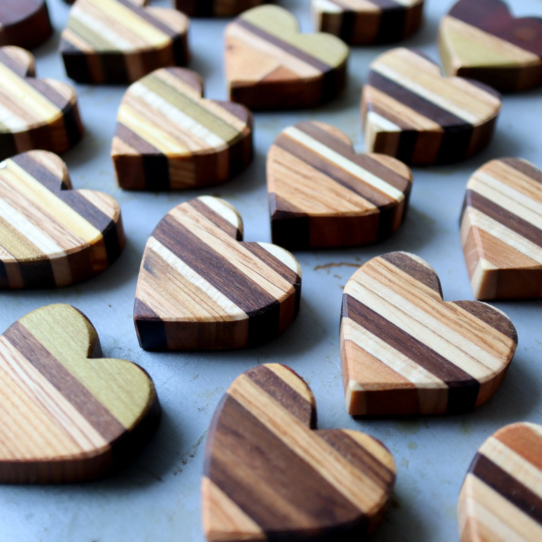 Striped wooden heart-shaped objects with diagonal wood grain patterns.