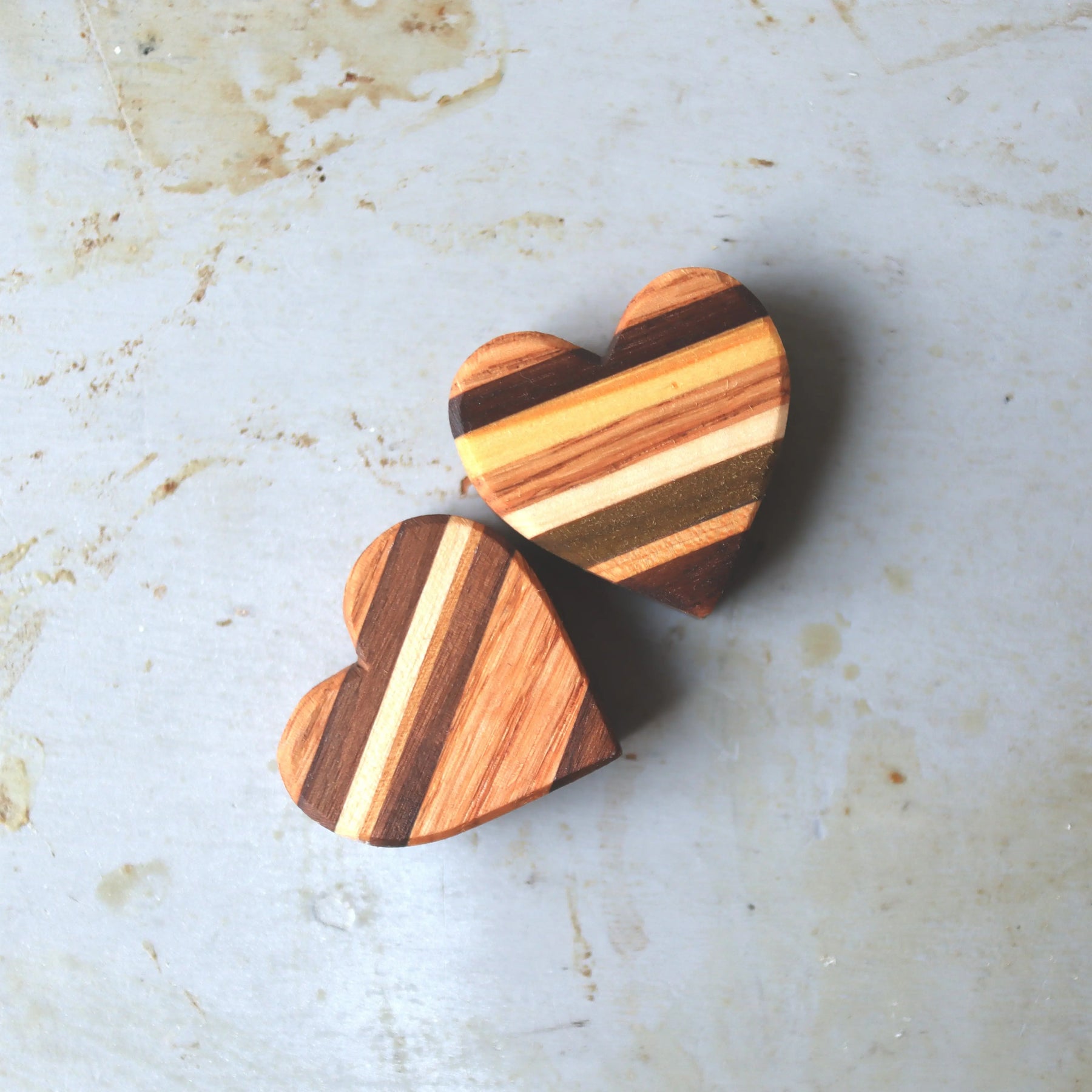 Two striped wooden hearts made of multi-colored wood pieces