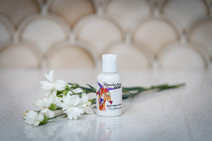 Small bottle of Appalachian Goat Tuberose Goat's Milk Lotion with white flowers