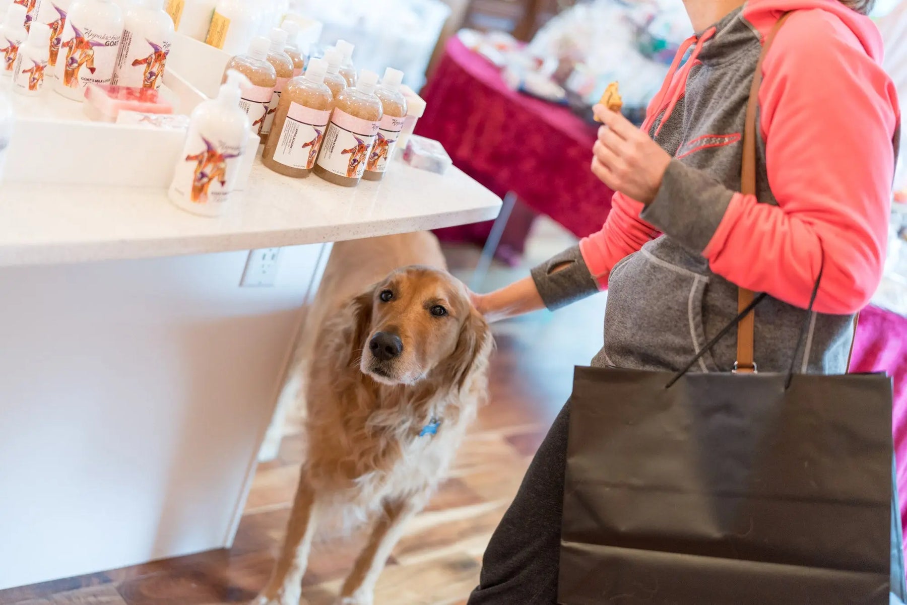 Appalachian Goat milk lotion bottles on display with a Golden Retriever dog