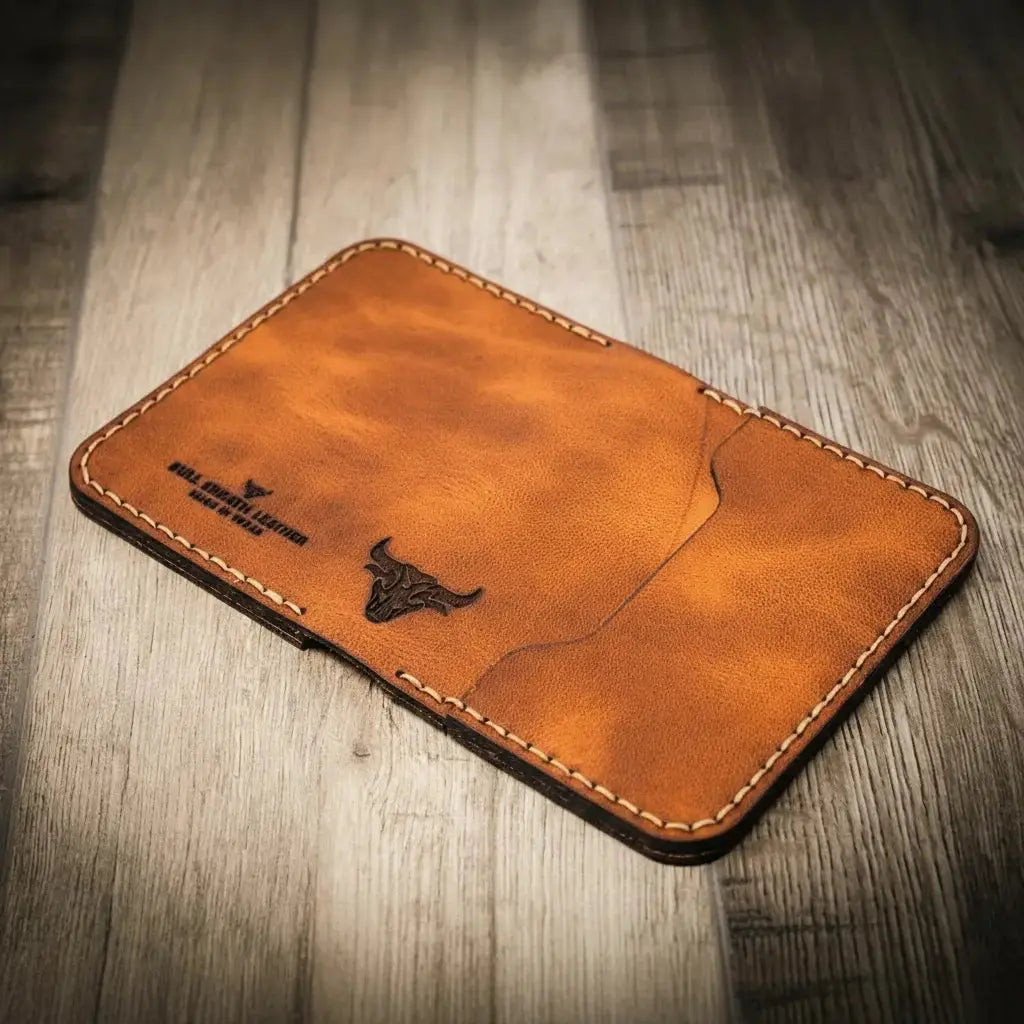 Brown leather bifold wallet with bull logo and stitching