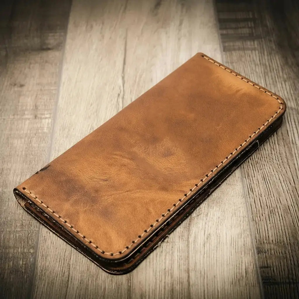 Brown leather long wallet with visible stitching on a wooden background.