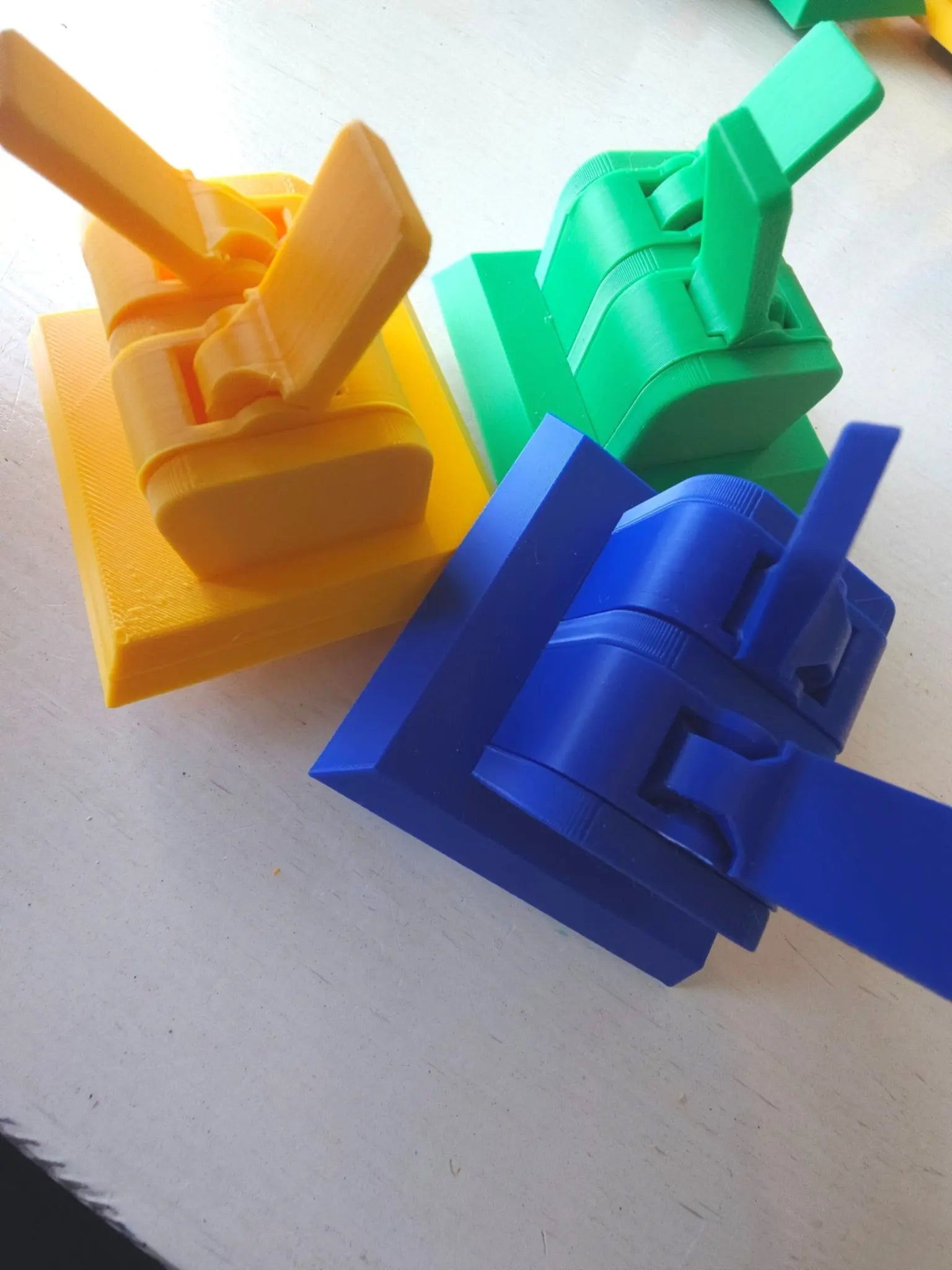Three colorful fidget cube faces with switches (yellow, green, blue) on a white background