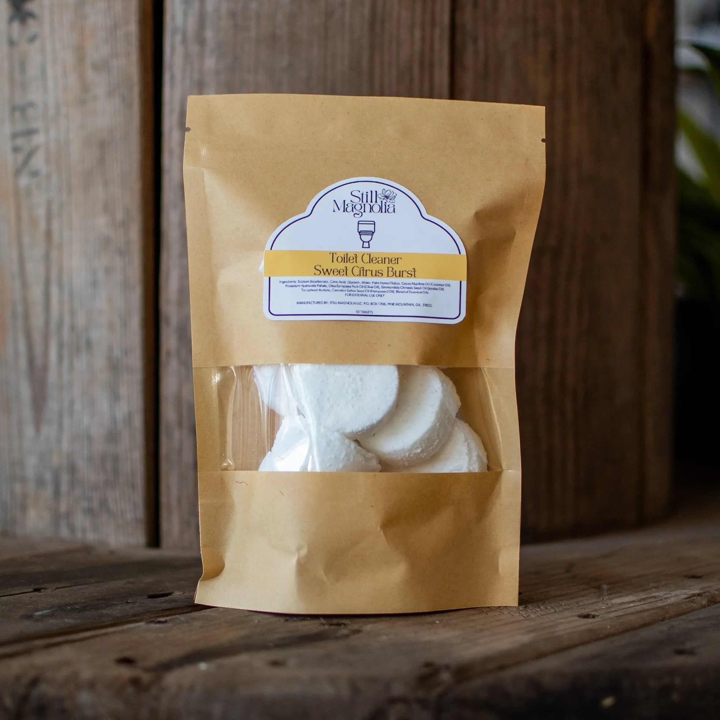 Toilet cleaner tablets in a brown paper bag with a clear window.