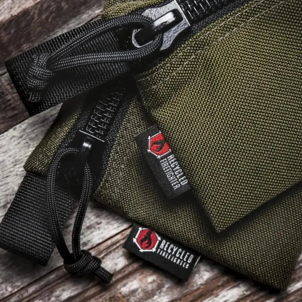 Olive green zippered pouch with Recycled Firefighter label and paracord pull.