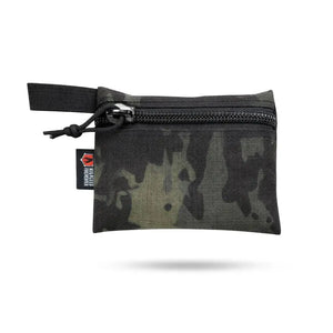 Small camouflage pouch with zipper and black webbing tab.