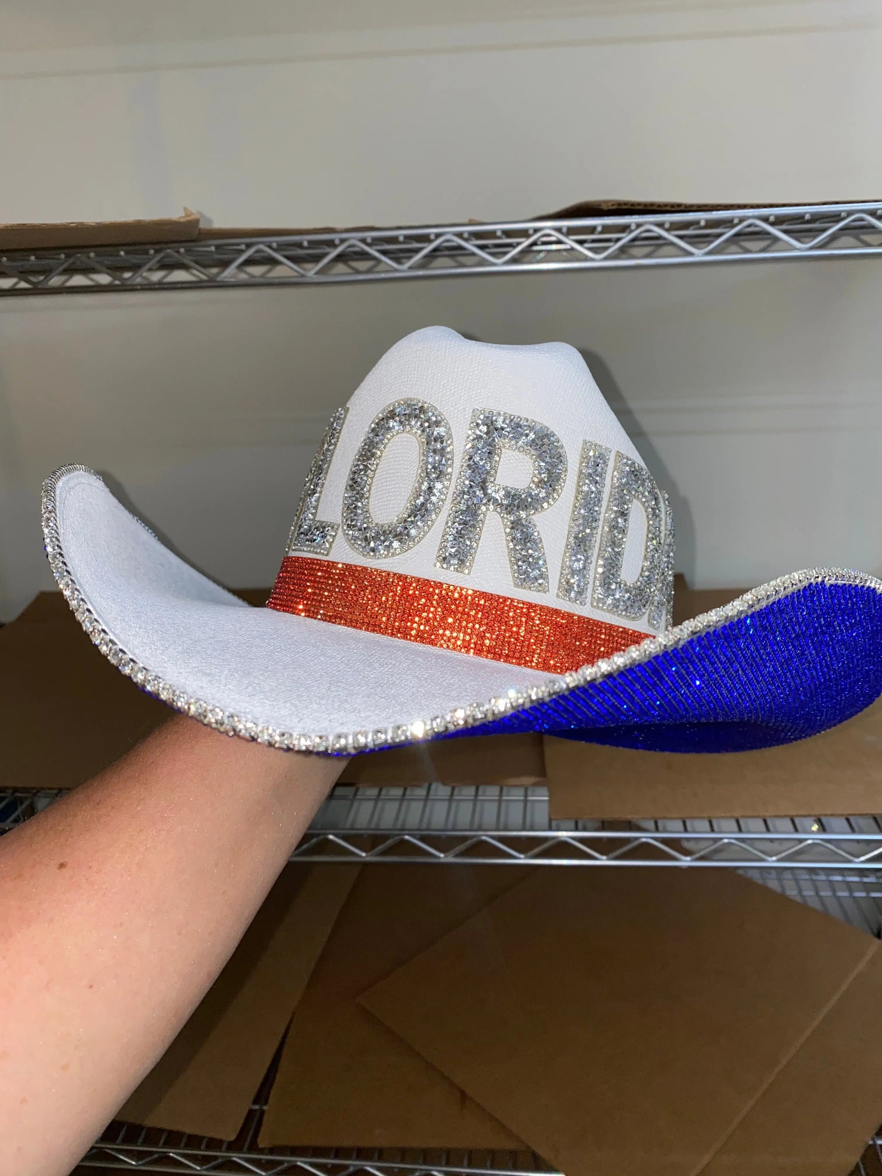 White cowboy hat with 'FLORIDA' spelled out in rhinestones and blue brim.