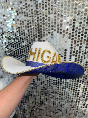 White cowboy hat with "MICHIGAN" in gold glitter and blue rhinestones
