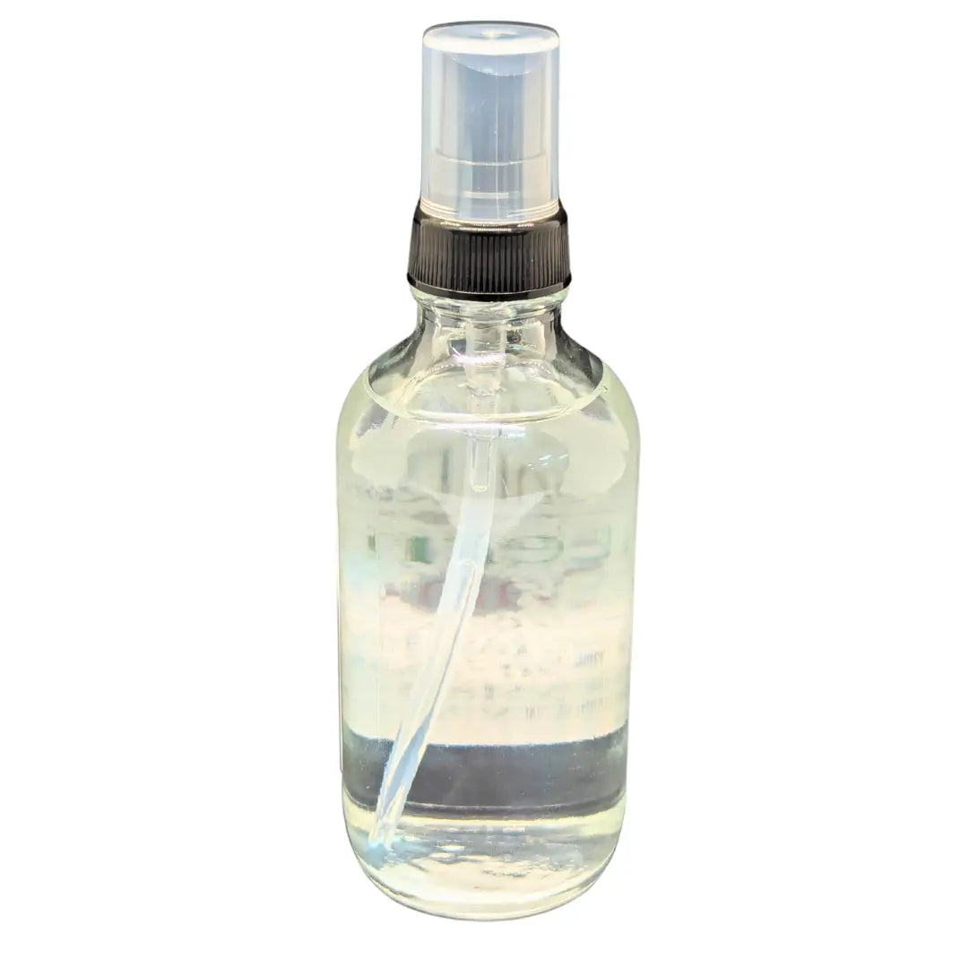 Clear glass spray bottle with black nozzle and cap filled with clear liquid.