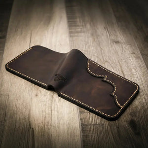 Black leather bifold wallet with white stitching and embossed design.