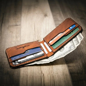 Brown leather bifold wallet with credit cards and US dollars
