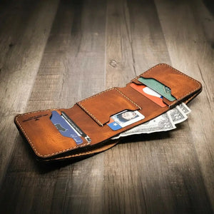 Brown leather trifold wallet with credit cards and cash.