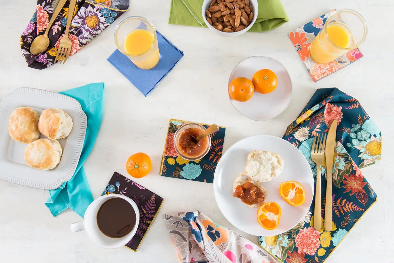 Winter Blue Floral Cloth Napkins set of four on a breakfast table with coffee, oranges, and biscuits.