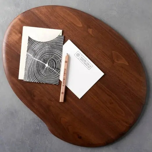 Walnut wooden lap desk with stationery including a card, envelope and pencil.