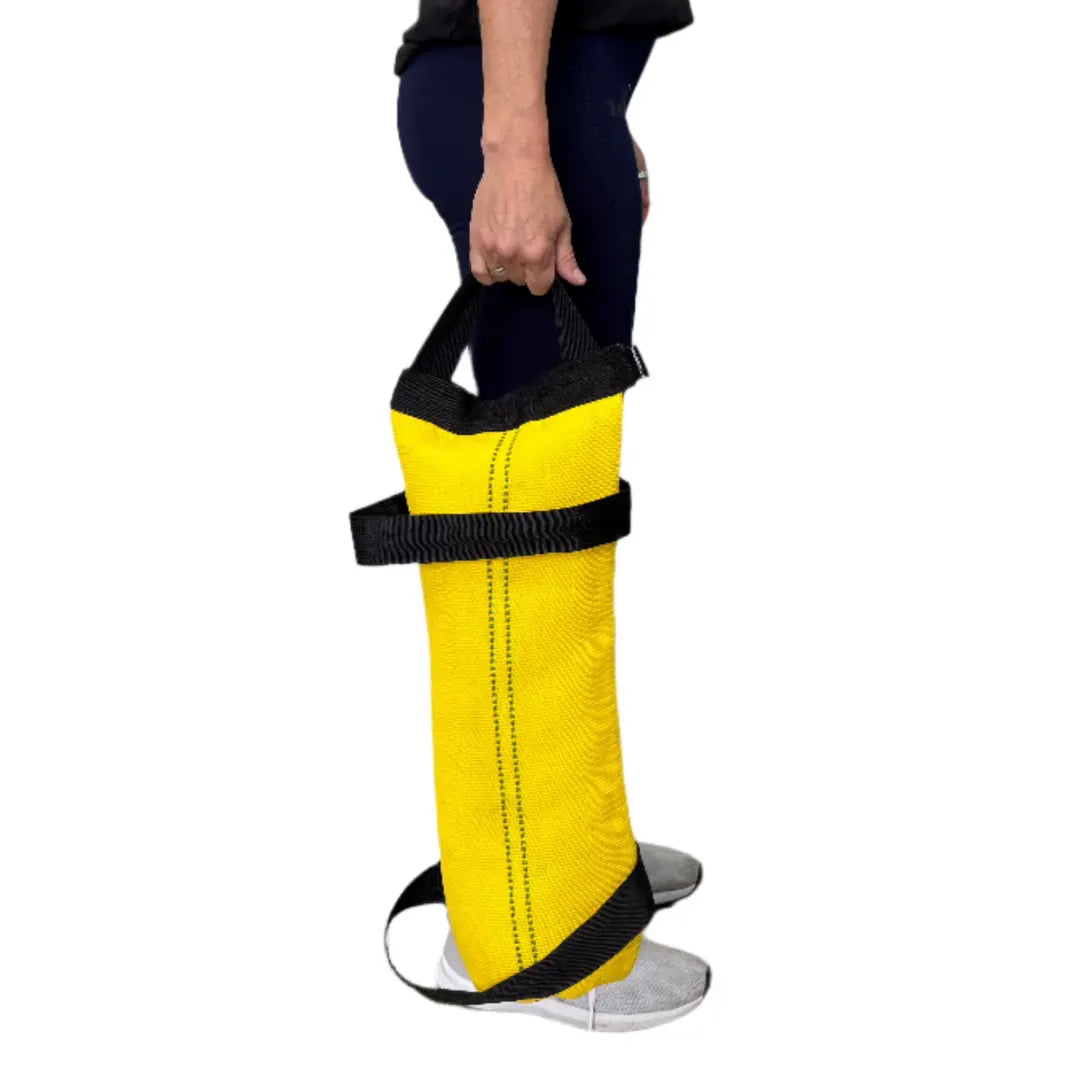Yellow workout battle bag with black handles and strap on a person\'s leg