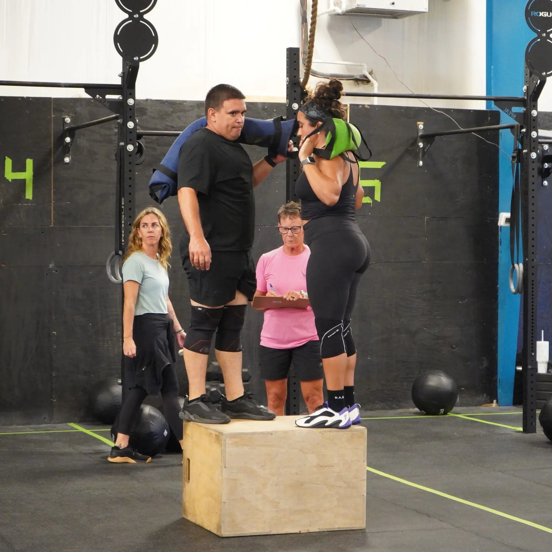 Men and women using a workout battle bag for strength training.