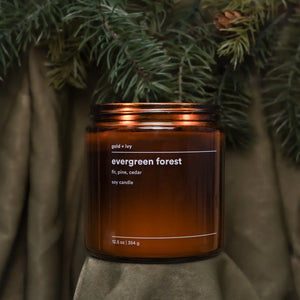Evergreen Forest candle with fir, pine, and cedar scent in an amber glass jar.