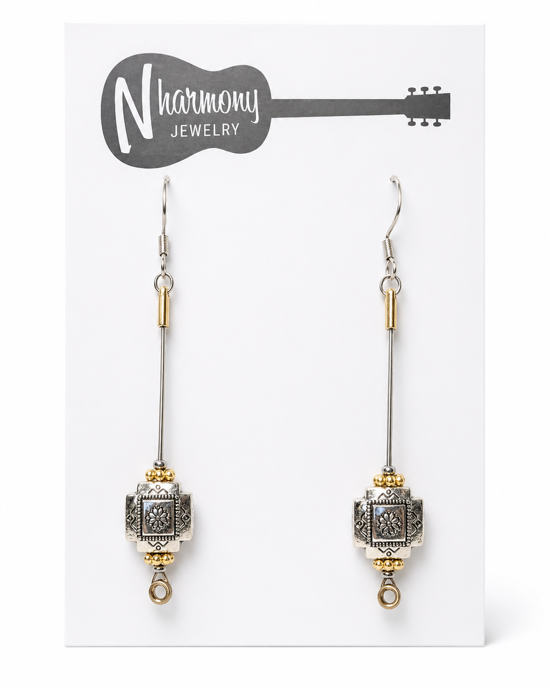 Decorative earrings on a 'N Harmony Jewelry' card with a guitar illustration.