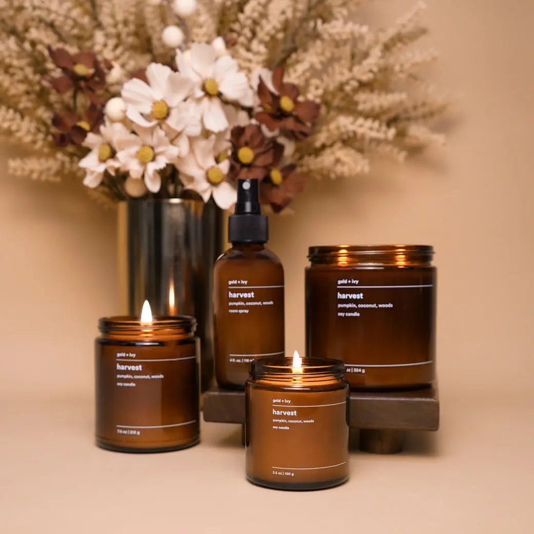 Amber glass "Harvest" scented soy candles and room spray from Gold + Ivy.