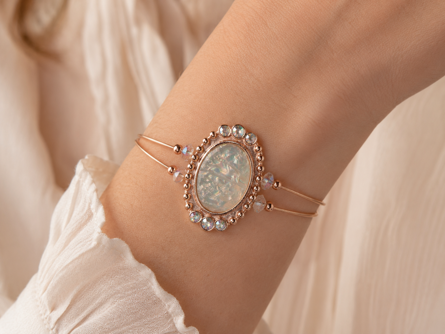 Delicate bracelet with gemstones on a wrist against a soft background
