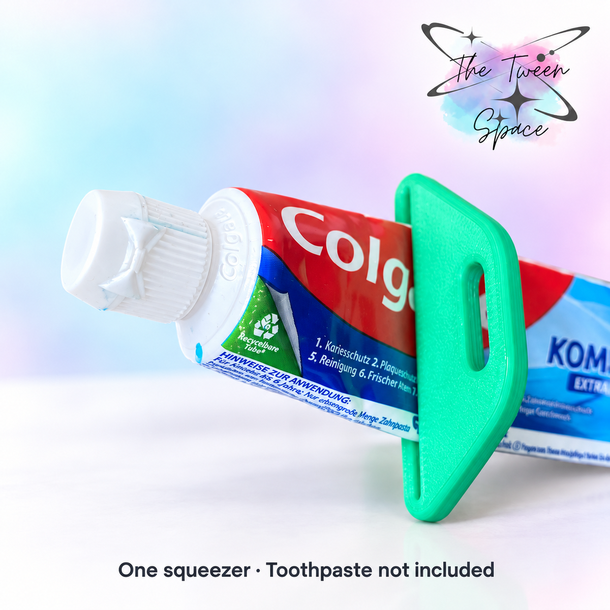 Green slotted toothpaste squeezer on a toothpaste tube with The Tween Space branding; toothpaste not included